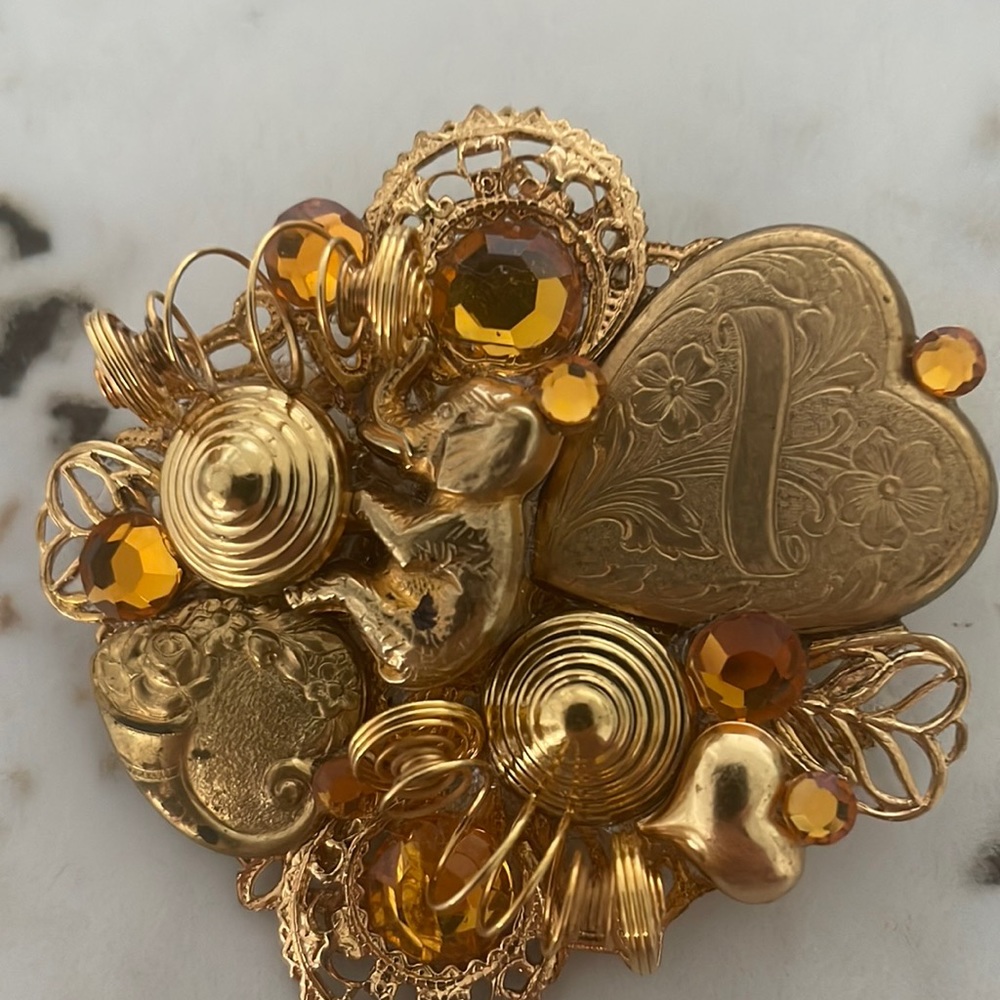 Topaz like and goldtone artsy heart detail brooch.